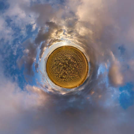 tiny planet in blue sky with beautiful clouds. Transformation of spherical panorama 360 degrees. Spherical abstract aerial view. Curvature of space.の写真素材