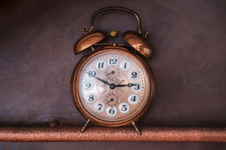 vintage old copper alarm clock on dark backgroundの写真素材