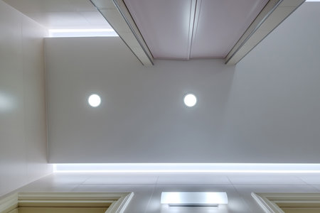 suspended ceiling with halogen spots lamps and drywall construction in empty room in apartment ,...