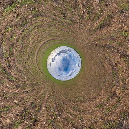 blue sphere little planet inside green grass round frame background.の写真素材