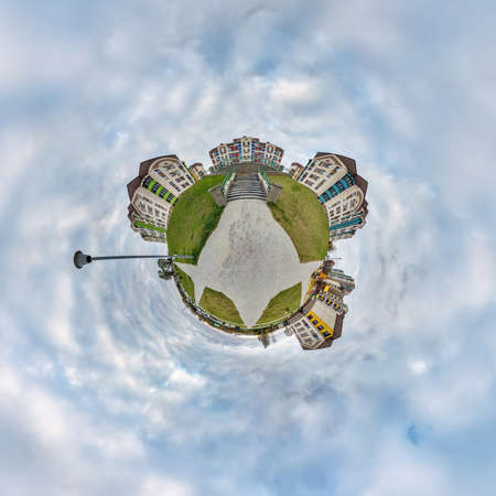 tiny planet in sky with clouds in modern multi-storey multi-apartment residential complex of urban...