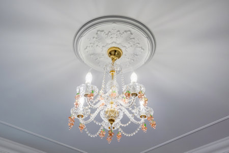 fashionable chandelier in a bright interior hanging under ceiling in palace, apartment or hotel
