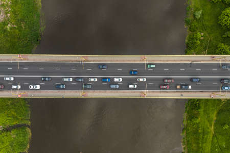 aerial view on heavy traffic on a bridge with a wide multi-lane road across a wide riverの写真素材