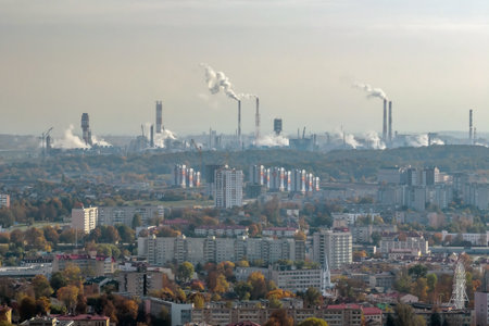ariel panoramic view of city with huge factory with smoking chimneys in the background