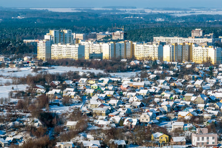 panoramic aerial view of a winter city with a private sector and high-rise residential areas with snowの写真素材