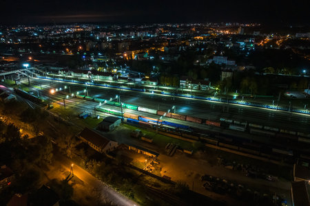 night aerial view over long railway freight trains with lots of wagons stand on parkingの写真素材