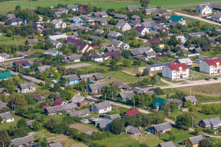 panoramic aerial view of eco village with wooden houses, gravel road, gardens and orchardsの写真素材