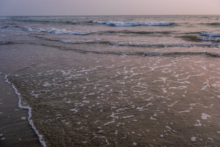 foam of sea or ocean waves against the backdrop of the setting sun
