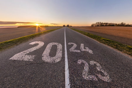 sign 2023, 2024 and start on asphalt road highway with sunrise or sunset sky background.  concept of...