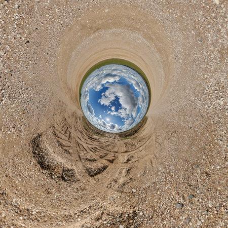 blue hole sphere or globe little planet inside sand or dry ground frame background with tractor tracksの写真素材
