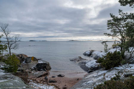 View of the rocky shore of Puistovuori and sea in winter, Hanko, Finlandの写真素材