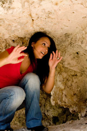 Young woman exploring rocky cave