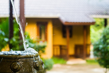 Water pouring into a earthenware with shallow dofの写真素材