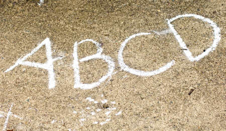 ABCD written in white chalk on concrete outsideの写真素材