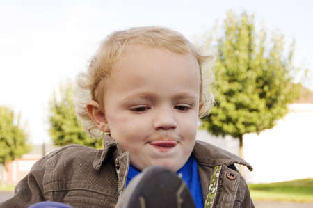 Young boy making funny face with tongue sticking out of his mouthの写真素材