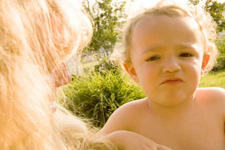 Young boy pouting outside during the summer