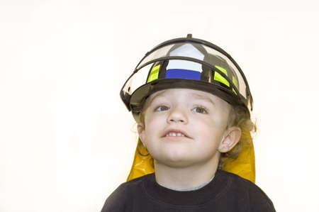 Young boy wearing black firefighter helmet with visorの写真素材