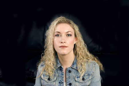 Beautiful blonde haired model head shot against black backgroundの写真素材