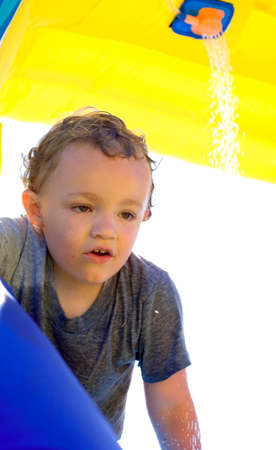 Young boy at top of water slide looking downの写真素材