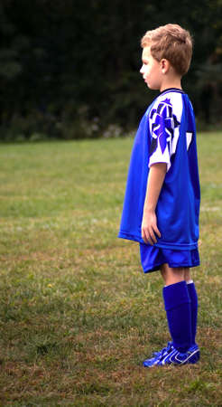 Young soccer player standing on field waiting for game to startの写真素材