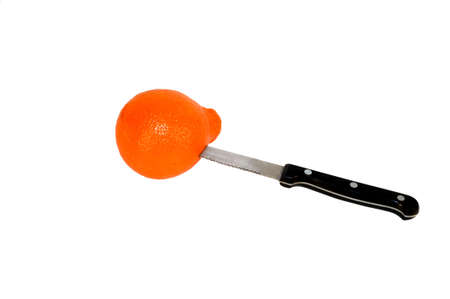 Serrated knife stuck into orange fruit peelの写真素材