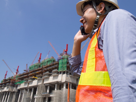 Construction worker using mobile phoneの写真素材