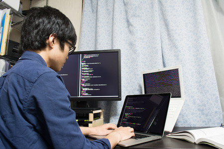Asian engineer writing a programme on a computerの写真素材