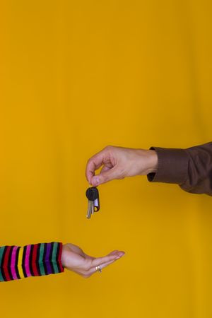 a bussiness man passing the keys to a young womanの写真素材