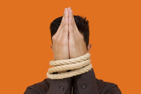 A bussinessmen tiedup by his fists with a yellow backgroundの写真素材