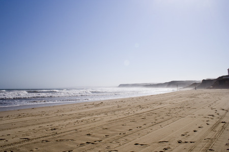 a landscape of a beach in a foggy morning
