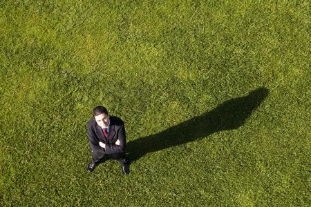 Above view of a businessman standing on the grass (with copy space)の写真素材