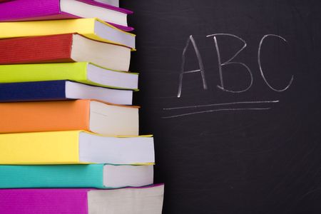 apple over a stack of books next to a chalkboard  (selective focus)の写真素材