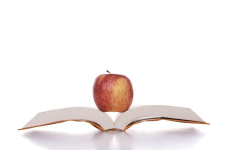 apple over a open book isolated on white (selective focus)の写真素材