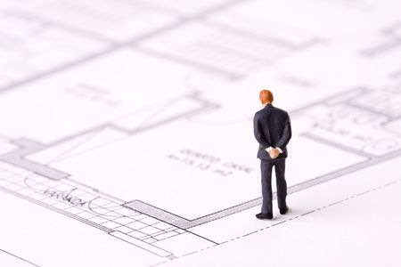 small businessman examining an architech blueprint (selective focus)