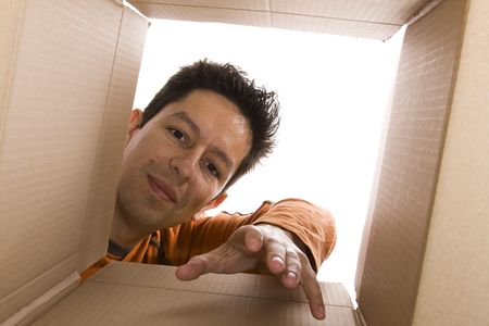 young men reaching something inside a cardboard box