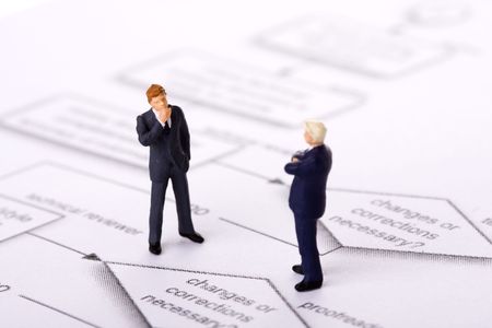 two little businessman thinking about a decision flowchart (selective focus)の写真素材