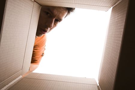 young man looking inside a cardboard box