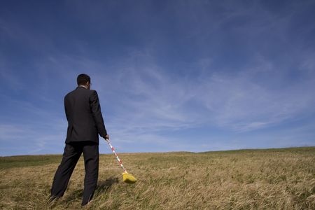 businessman cleaning the field with a broom