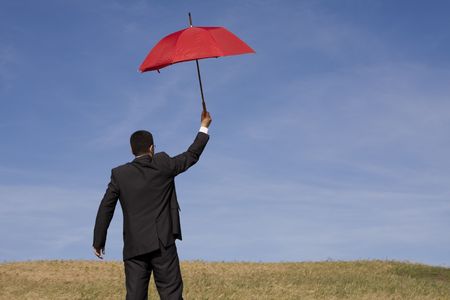 Businessman finding protection outside in the fieldの写真素材