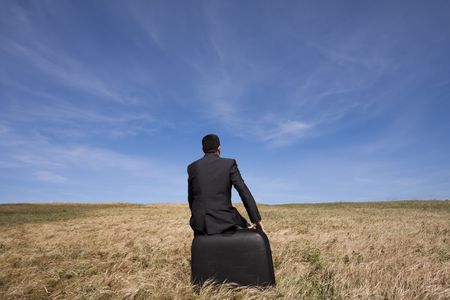 businessman with his luggage outdoor in the fieldの写真素材