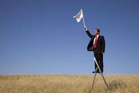businessman asking for surrending with a white flagの写真素材
