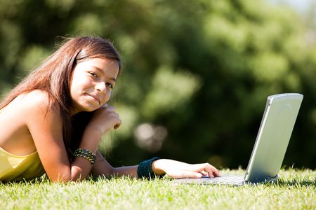 little girl studing with her laptop at the parkの写真素材