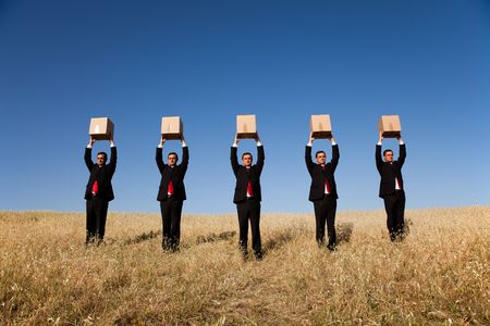 five businessman lineup holding a cardboard box over his headの写真素材