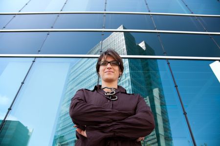 successful businesswoman looking down next to her office buildingの写真素材