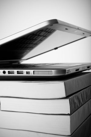Colorful books next to a modern laptopの写真素材