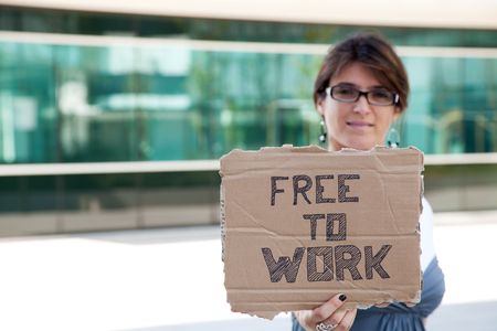 unemployed woman showing a message in a cardboard that she is free to workの写真素材
