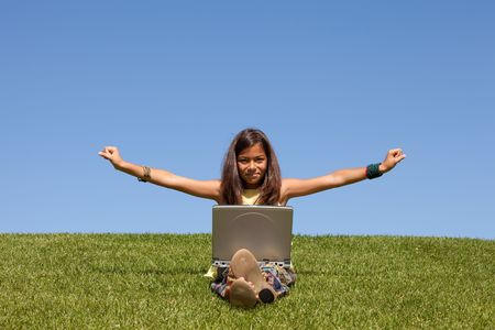Young girl using wireless internet at the parkの写真素材