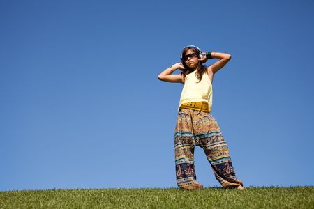 young female child listening music outdoorの写真素材