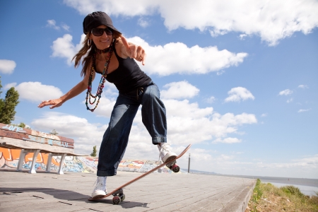 cool skateboard woman at a public graffiti parkの写真素材
