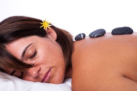 young beautiful woman in a spa enjoying a hot stone treatmentの写真素材